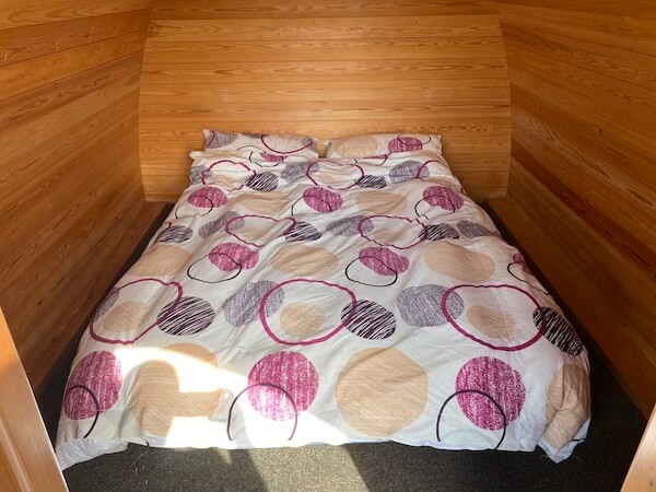 futon with duvet inside wooden glamping pod