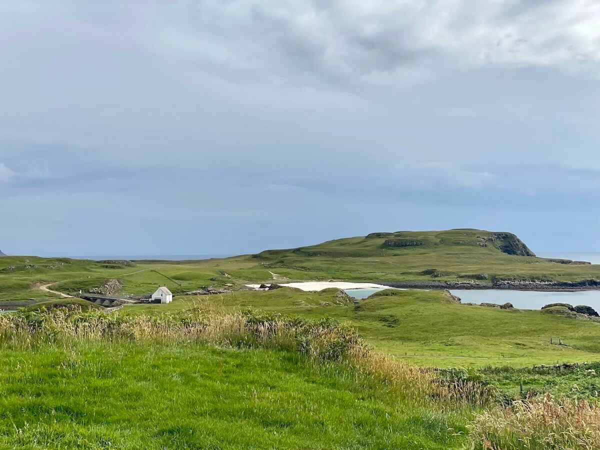 view across green land and to Sanday beach and isle from Canna Campsite