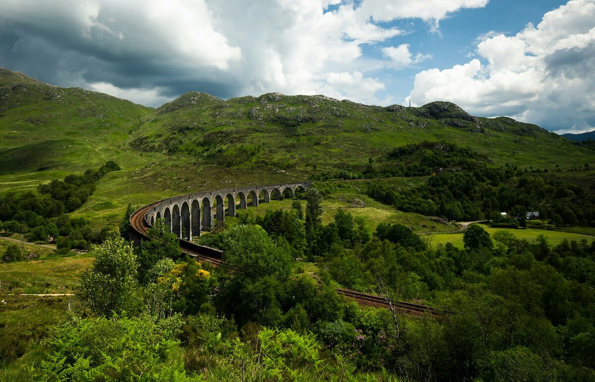 Glenfinnan Viaduct set among lush greenery and hills in the background