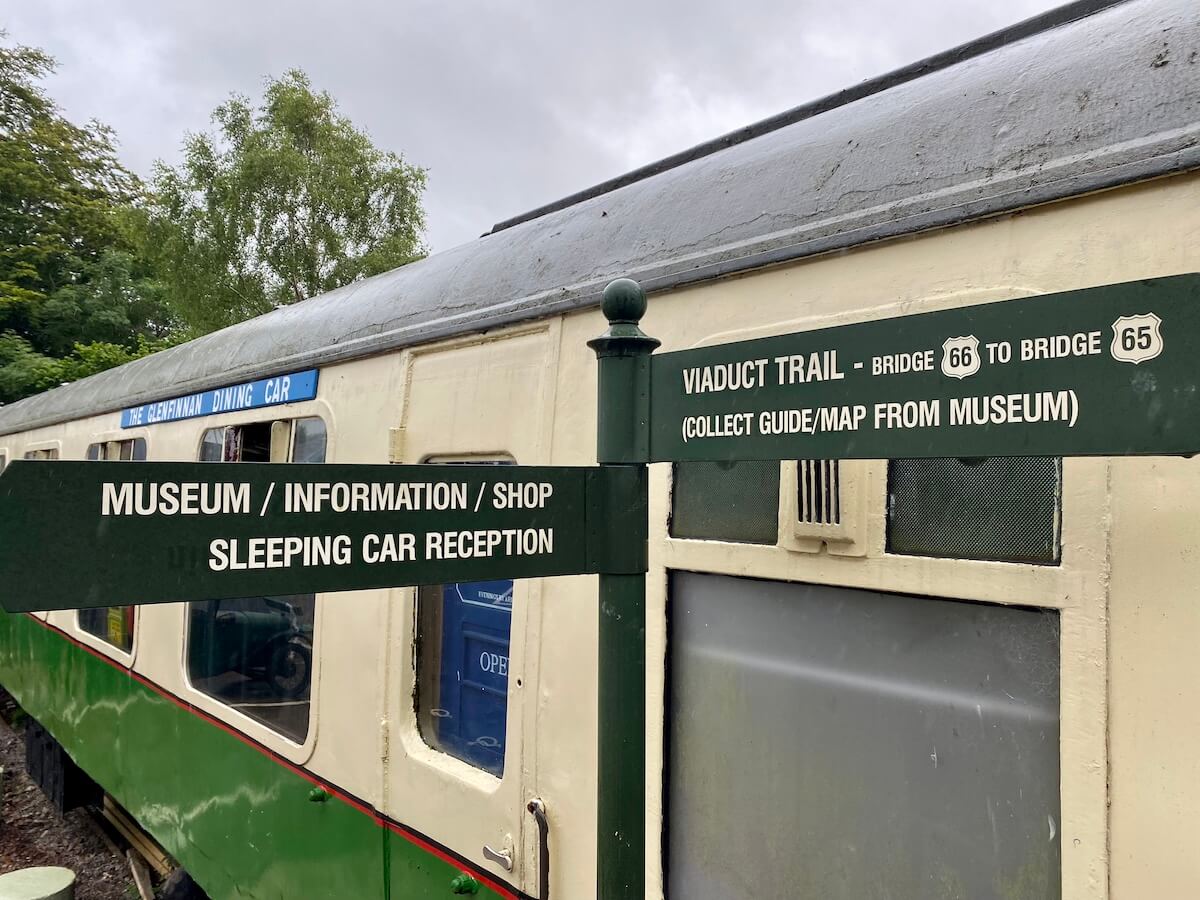signpost in front of old dining car at Glenfinnan dining car museum